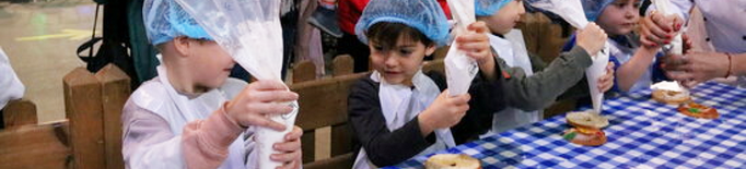 Desenes d'infants aprenen a elaborar tortells de Reis a Lleida