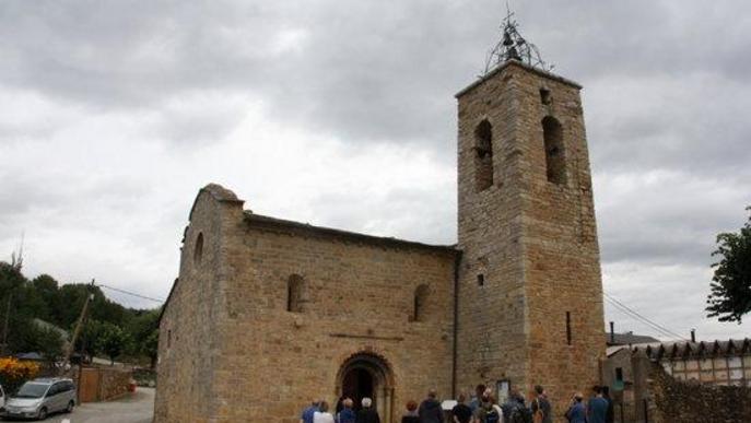  l'exterior de l'església de Santa Maria d'All, a Isòvol (Cerdanya), on es pot veure un grup de visitants mirant la portalada.