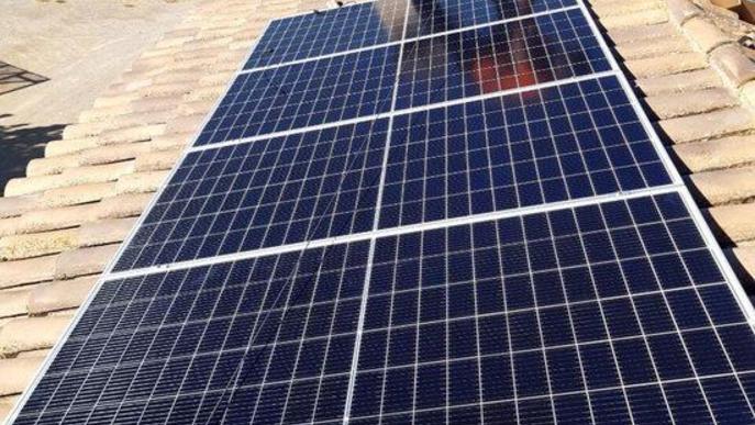 Pla obert d'un operari instal·lant una placa solar a un habitatge de l'EMD de Raimat
