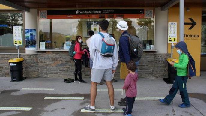 Pla obert on es veuen diverses persones comprant forfets i entrades per dur a terme diverses activitats a l'estació de La Molina