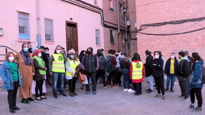 Imatge de la dona que viu a pis del barri de la Mariola de Lleida, que s'havia de desnonar, amb membres de la PAH de Lleida