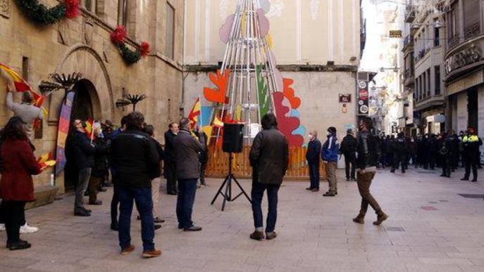 Pla general de la plaça de la Paeria de Lleida durant l'acte de Vox, mentre al fons un cordó policial impedeix als manifestants antifeixistes accedir a la plaça