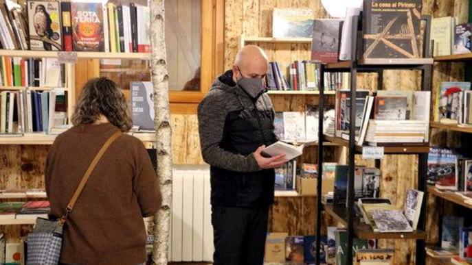 Pla general de dos persones fullejant llibres a NaturaLlibres d'Alins