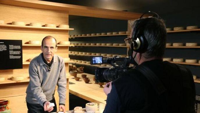 Pla obert del gastrònom Pep Palau durant la gravació d'un nou vídeo de tast de formatges per al canal virtual de la Fira de Sant Ermengol de la Seu d'Urgell i on es veu també el càmera encarregat de l'audiovisual