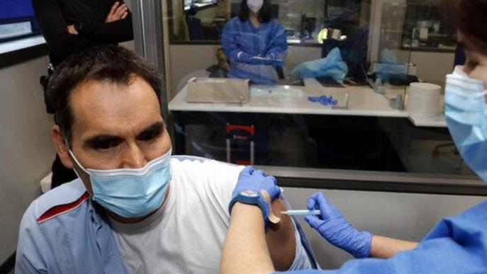 Pla mitjà on es pot veure una infermera administrant la primera dosi de la vacuna AstraZeneca a un agent dels Mossos d'Esquadra a la comissaria de Lleida