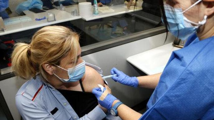 Pla mitjà on es pot veure una infermera administrant la primera dosi de la vacuna AstraZeneca a una agent dels Mossos d'Esquadra a la comissaria de Lleida