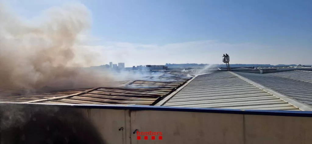 Els Bombers treballen en l'extinció d'un incendi en una nau industrial a Cervera