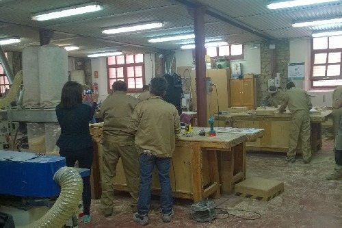 Persones sense llar participen en un taller de mobles