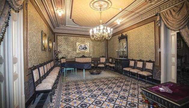 Un dels salons de la casa senyorial Duran i Sanpere de Cervera i, a la dreta, la capella privada de l’edifici, amb els personatges de les pintures inspirats en la mateixa família.