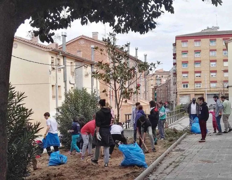 Joves escoltes netegen una zona verda del barri de la Mariola