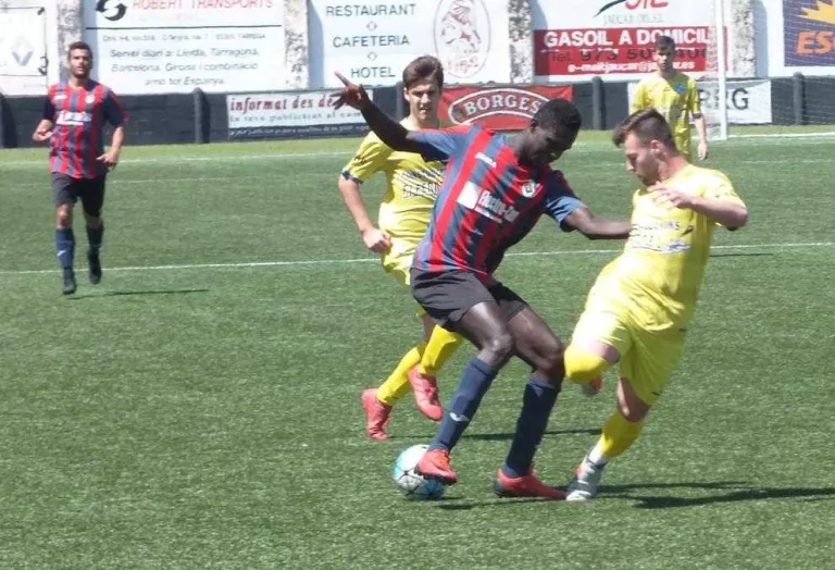 Sylla, del Tàrrega, intenta controlar una pilota davant de l’oposició de dos jugadors del Cambrils.