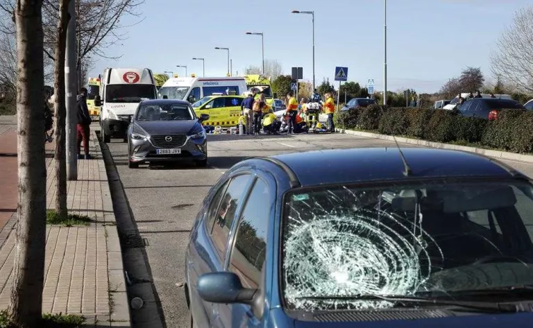 El vehicle del conductor ara empresonat i, al fons, l’atenció a la víctima.