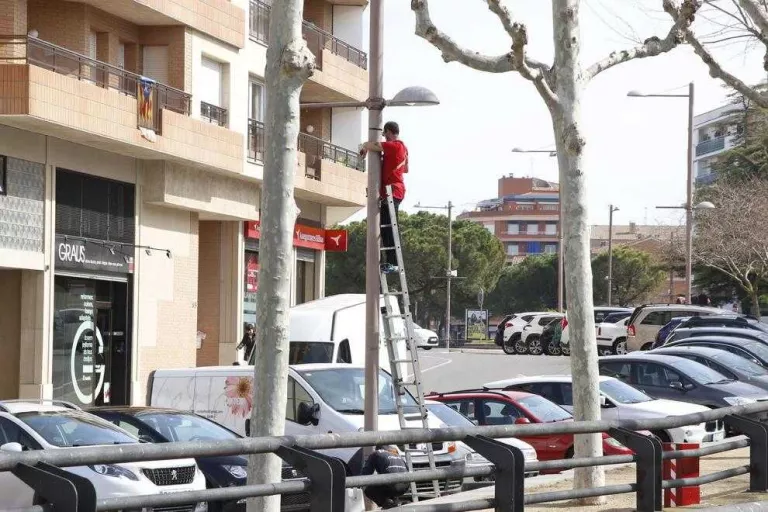 Un operari al despenjar ahir a Mollerussa els cartells que anunciaven la Fira de Sant Josep.