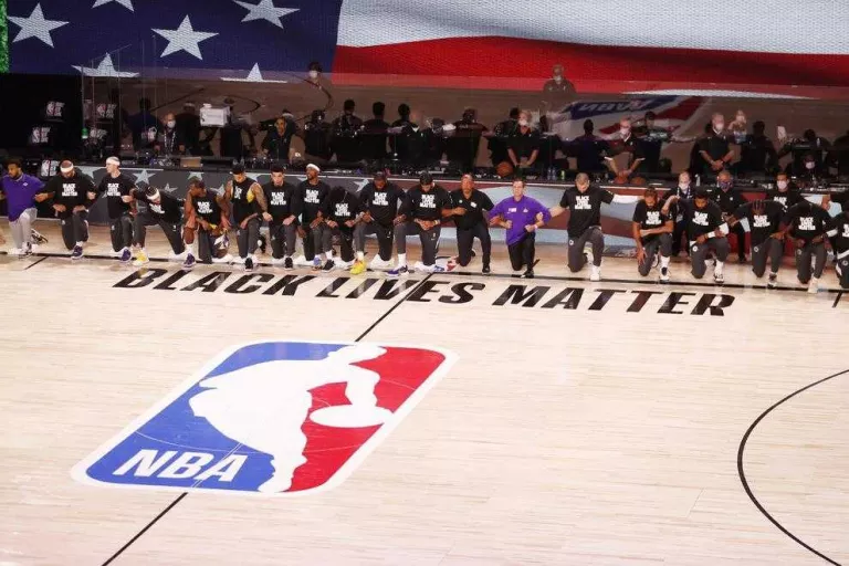 Els jugadors dels Lakers i els Clippers s’agenollen durant l’himne nacional dels EUA.