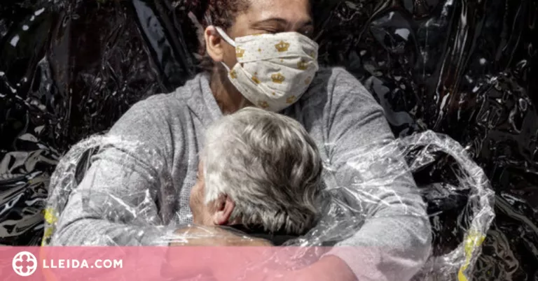 Una abraçada protegida amb plàstic per evitar la covid-19, premi World Press Photo 2021