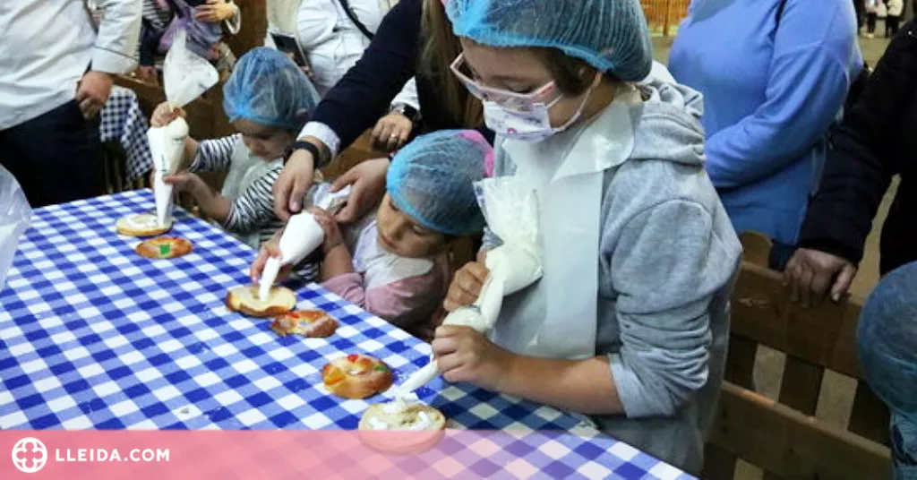 Desenes d'infants aprenen a elaborar tortells de Reis a Lleida