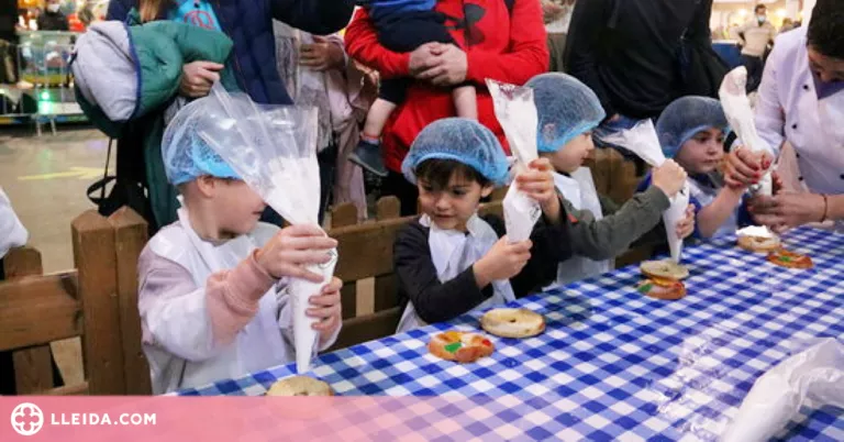 Desenes d'infants aprenen a elaborar tortells de Reis a Lleida